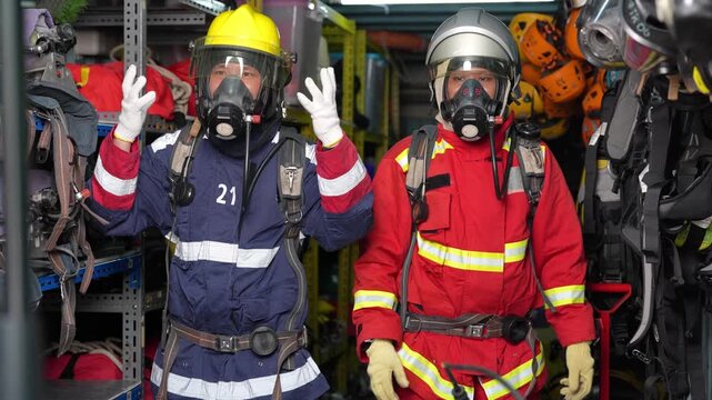 Firefighter respirator helmet protective suit breathing safety emergency training rescue equipment, responders sort oxygen tanks in equipment room and warehouse, focused teamwork during indoor drill