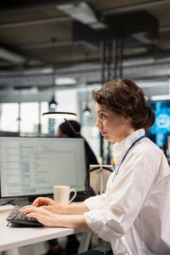 Female engineer tests machine learning algorithms in a startup office, using large language model technology to improve performance and scale productivity for an artificial intelligence project.