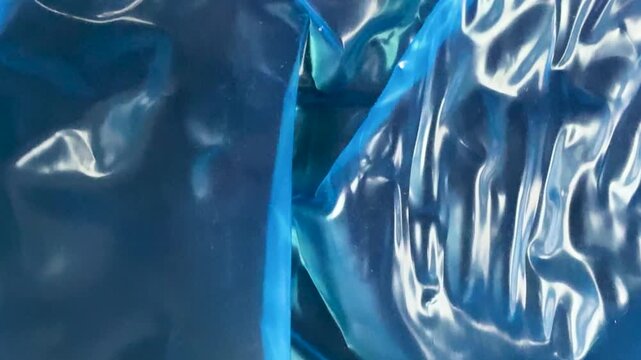 Shiny blue wrinkled plastic film texture background