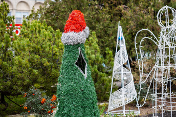 Obraz premium Christmas decorations in park with santa hat on wire structure
