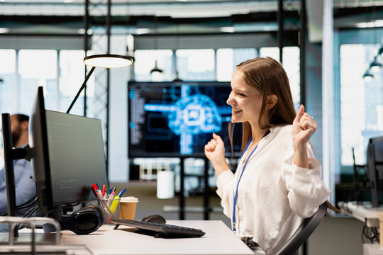 Overjoyed technology startup intern dances on an office desk chair after streamlining workflows with AI, celebrating the successful implementation of artificial intelligence.