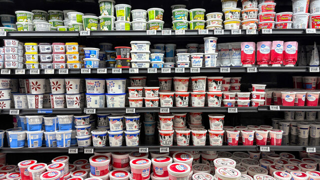 Refrigerated dairy section of a grocery store with sour cream and cottage cheese products.