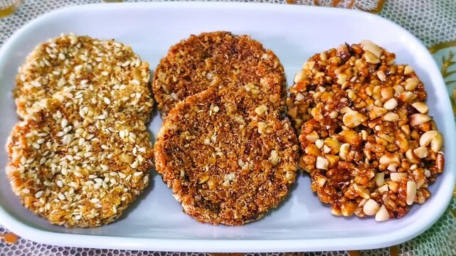 Assorted traditional Indonesian enting enting sweet peanut brittle and sesame seeds candy served neatly on a white ceramic plate high angle view concept for authentic Asian snacks and food photography