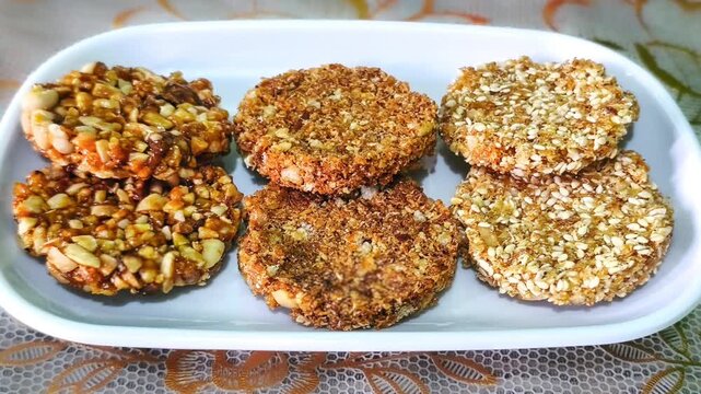 Assorted traditional Indonesian enting enting sweet peanut brittle and sesame seeds candy served neatly on a white ceramic plate high angle view concept for authentic Asian snacks and food photography
