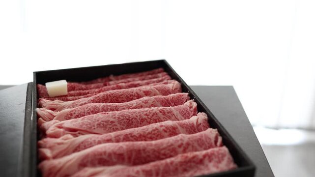 すき焼き用和牛。高級霜降り牛肉を黒い箱に美しく盛り付け。