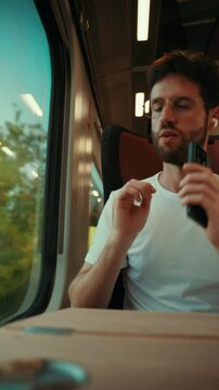 Italian man sings and dances while listening to music with earphones on train