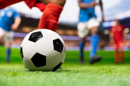 Soccer player breaks away in attack and kicks the ball, running forward with dribbling skill and motion blur before shooting toward goal in a competitive stadium match on the football pitch.