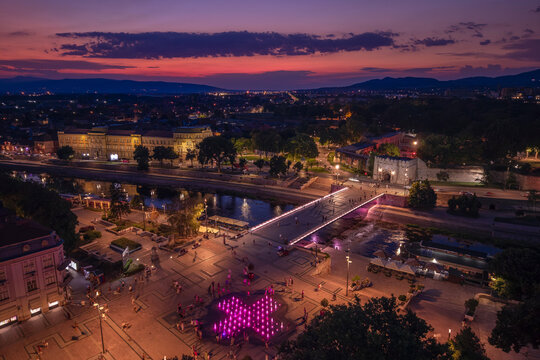 Night view of a city of Nis square with a bridge and colorful lights