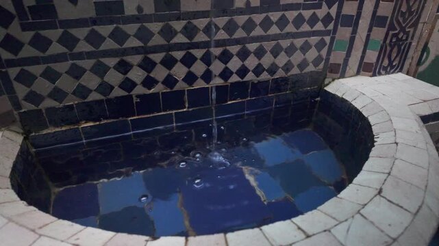 Water Gently Flows into a Beautiful Tiled Fountain with Ornate Patterns