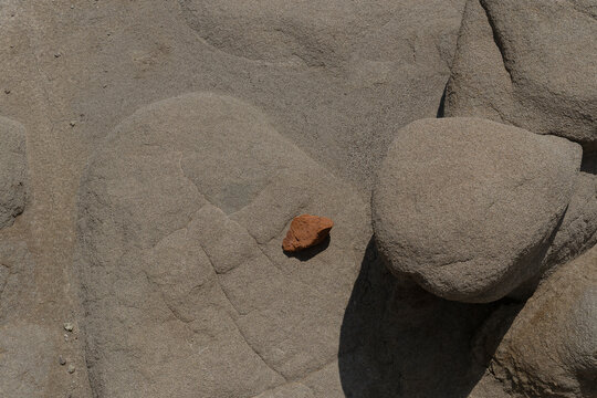 Close view of sandy rocks with contrasting burnt orange stone