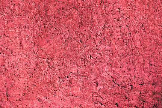 Red background, photo of the texture of an old wall with various lines, embossing, and brushstrokes