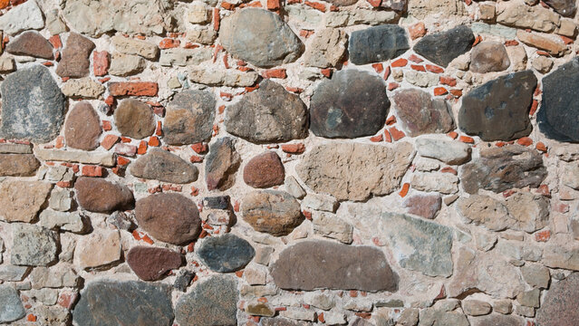 The photo shows a wall made of old brick and stone