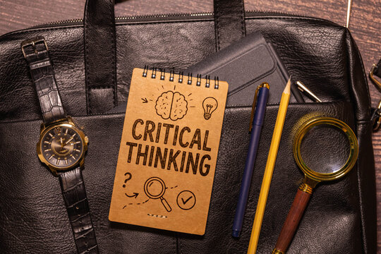 Critical Thinking Concept with Brain, Magnifying Glass and Business Workspace.