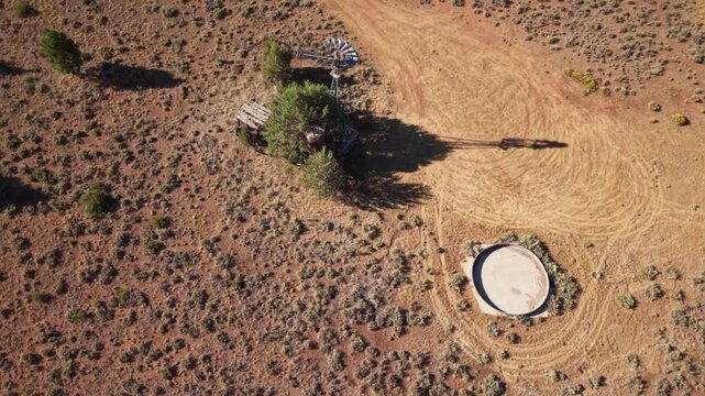 Drone flyby and banking turn over defunct windmill and stock tank at Dow Wells, Lassen County, California.