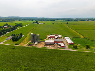 Aerial view of green agricultural farmland with farmhouses barns and fields © Will