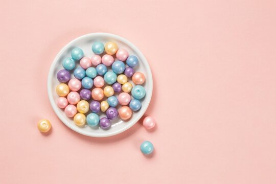 Pastel colored Easter eggs on white plate isolated on pink background, colorful holiday sweet treats and spring food photography