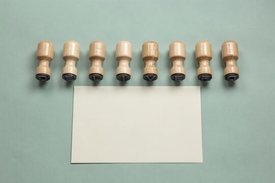 Set of eight wooden stamp handles with blank white card sheet, desk arrangement for business office branding and copy space