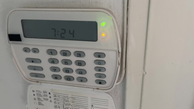 Home security alarm system keypad transitioning from armed to disarmed status with green and yellow indicator lights blinking on the digital control panel