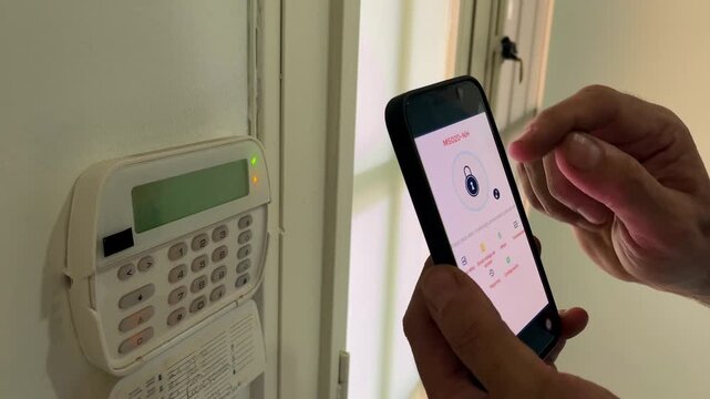 Person programming home security alarm system with keypad and smartphone application for remote access, safety and property protection using a modern smart home network