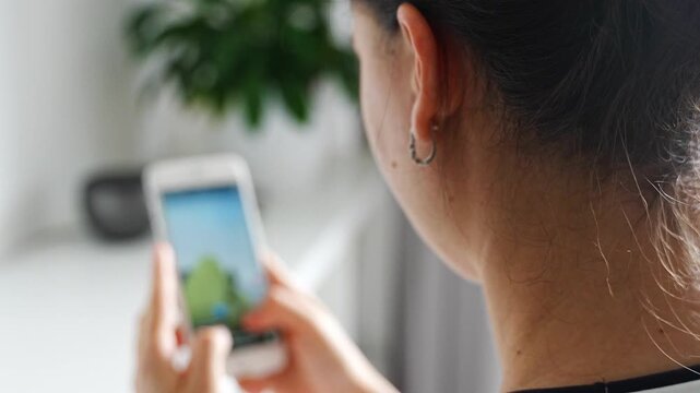 Woman scrolling social media on a smartphone at home. Digital addiction concept with endless content consumption and screen time.