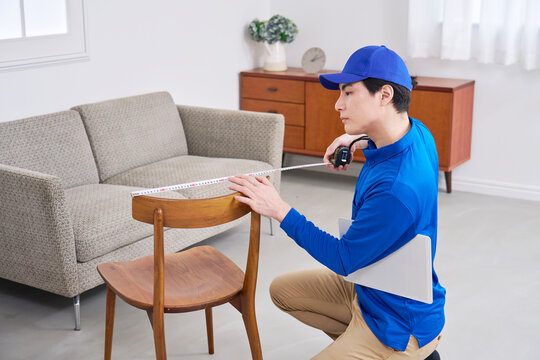 椅子のサイズを測る作業員