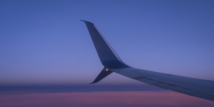 Airplane Wing Silhouette Against Purple and Blue Twilight Sky