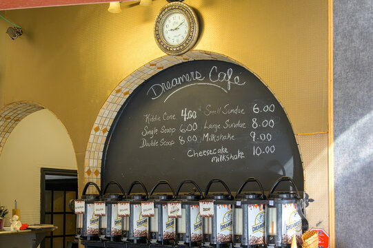 Dreamer's Cafe menu and coffee dispensers beneath a decorative wall clock, Port Hope, Canada