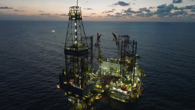 Offshore drilling rig - jack up and offshore platform during sunset for oil and gas exploration and production. 
