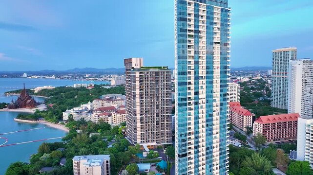 An aerial view of luxury resort condominiums with lush green gardens along the Pattaya waterfront and turquoise sea.