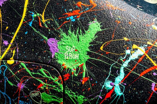 vibrant paint splatter on urban concrete surface close-up of a car