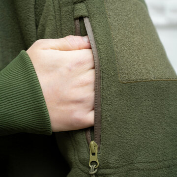 Person's Hand in Pocket of Green Fleece Jacket