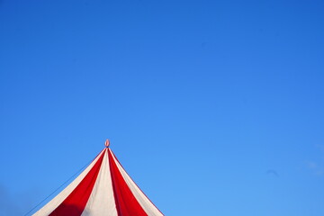 Red and White Carnival Tent Peak Against a Clear Blue Sky © Aisyah Faiha