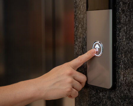 A woman calls an elevator. Tactile buttons for the visually impaired.