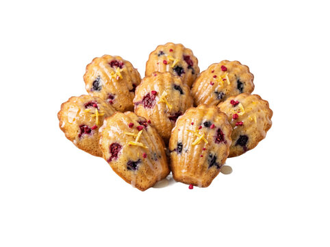 Fresh berry madeleines on white background. Isolated citrus sponge cakes with summer fruit.