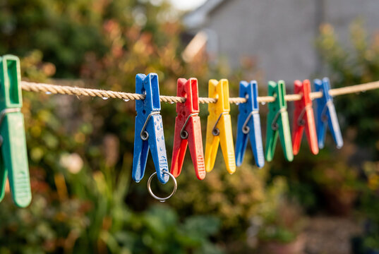 Colorful plastic clothes pegs clipped onto a taut laundry line