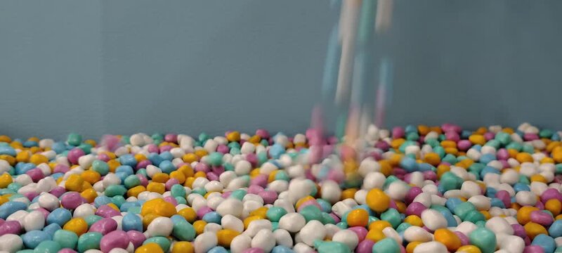 Colorful Small Spheres Falling into a Pile of Similar Spheres.