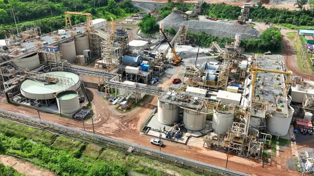 Aerial view of a gold mining processing plant with industrial equipment, crushing facilities, and material handling systems, showcasing modern mineral extraction and large-scale mining operations. 4k.