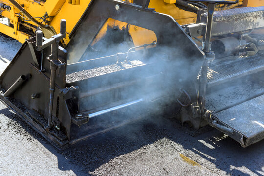 Work on road construction site where asphalt is being laid