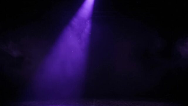 A dramatic beam of purple light pierces through a dark, smoky atmosphere, illuminating a stage in an empty theater, hinting at an unseen performance and a captivating ambiance.