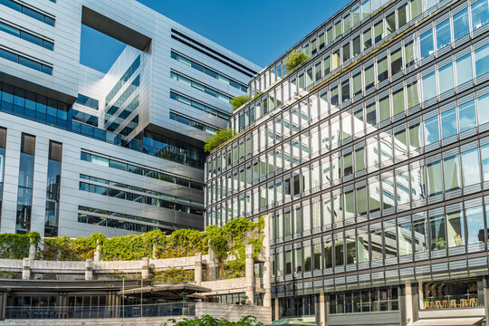 View of modern office buildings with glass facades, green terraces, and stone architectural details in the City of London, London, England, United Kingdom.
