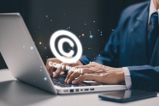 Business professional works on laptop with a copyright symbol, illustrating intellectual property, digital rights, content protection, ownership, licensing, and legal compliance concept.