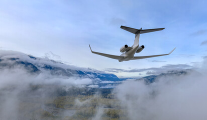Naklejka premium Private Business Jet Flying Over Misty Mountains and Clouds Above BC Canada — 3D Rendering