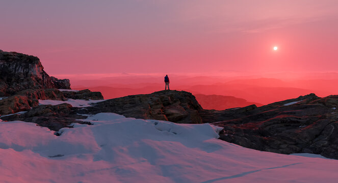 Lone Hiker on Snowy Mountain Ridge at Pink Sunrise Over Misty Valleys, Solitude and Adventure