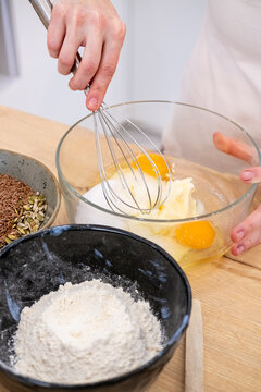 Baker occupation. Mixing dough. Female hand stirring liquid egg flour batter with whisk at home kitchen workplace preparing dessert.
