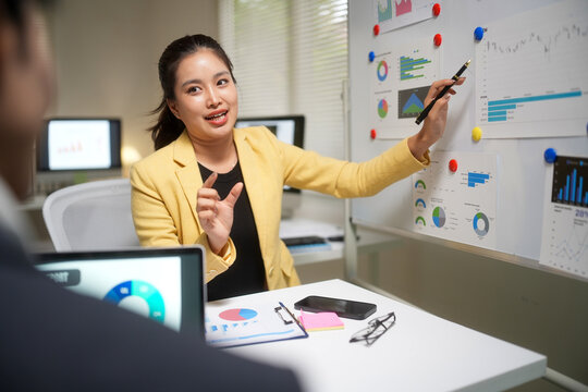 Businesswoman Presenting Financial Charts in Office Meeting