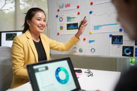 Businesswoman Presenting Financial Charts in Office Meeting