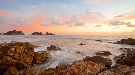Obraz premium Coastal landscape with rocky shoreline and sunset sky at golden hour