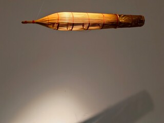 Vintage Airship Model: A detailed model of an early airship, with a woven basket and metallic accents, hangs suspended, casting a long shadow. © Vixay