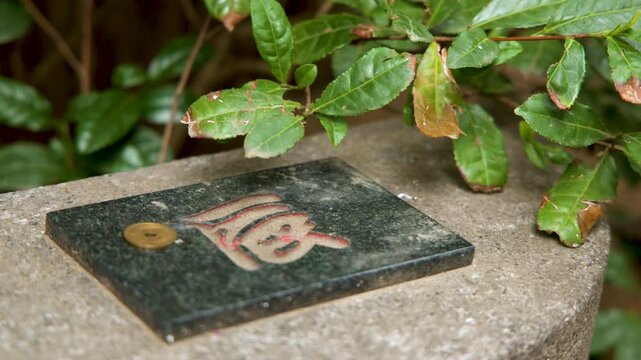 Japanese Yen Coin Offering on Stone Tablet with Kanji