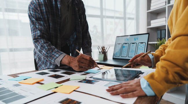 Ux ui designers collaborating on mobile application wireframes